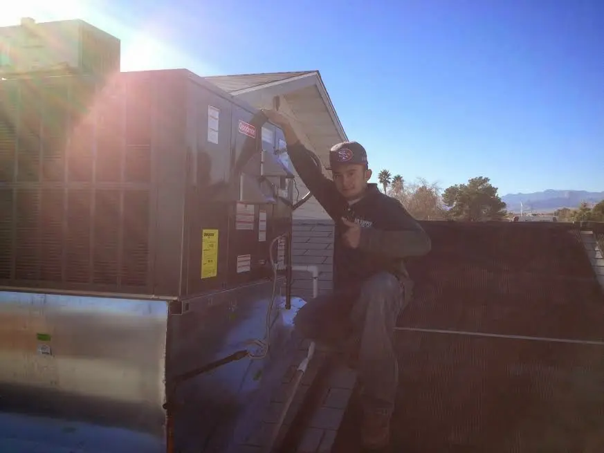 HVAC technician performing Air Duct Repair on a rooftop unit in Kimball